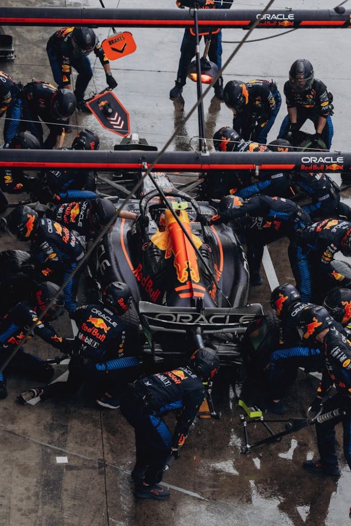 f1-pit-stop-crew-working-on-race-car-29327972 Dynamic pit stop scene with F1 crew servicing a race car during a competition.